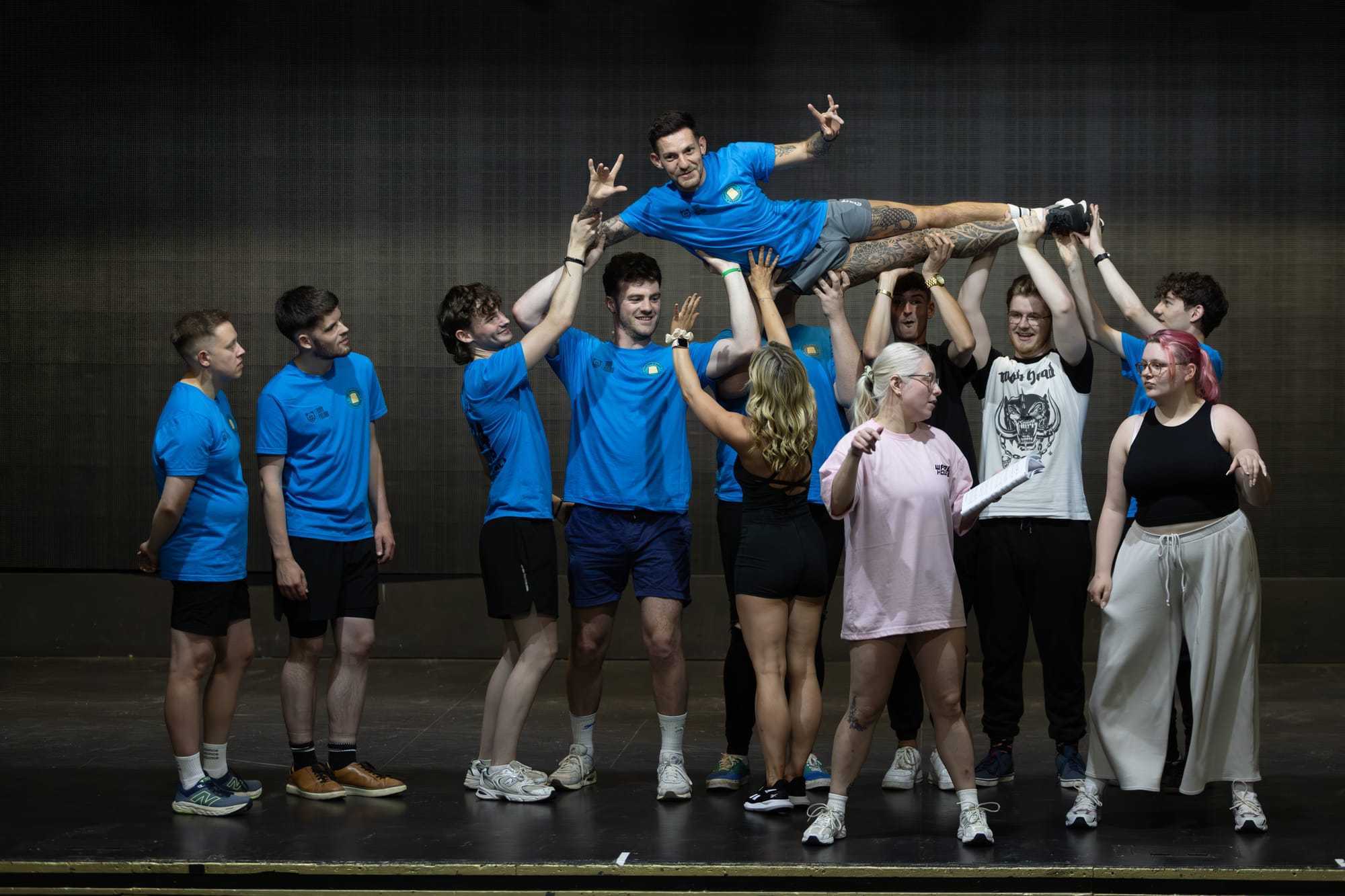Cast members lift a performer during rehearsals for the 24 Hour Musical
