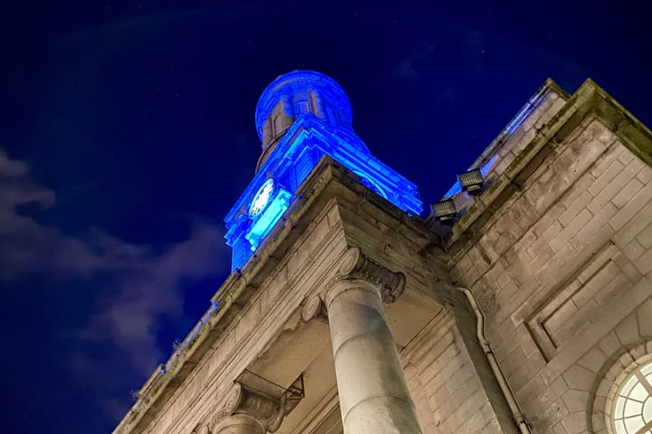 Aberdeen Arts Centre's clock tower and dome lit blue against a night sky