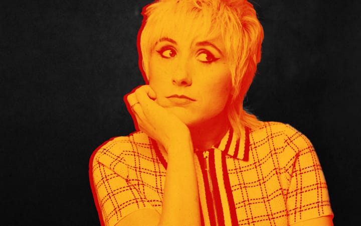 Maisie Adam, red and yellow portrait, resting chin on hand