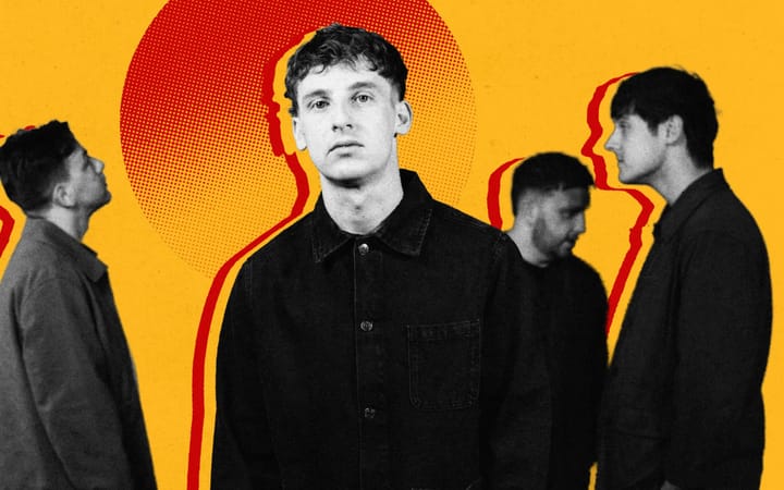 Jack Cochrane stands centre frame as bandmates talk in the background, yellow and red design