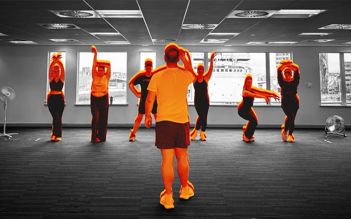 Cast members rehearse choreography in a studio