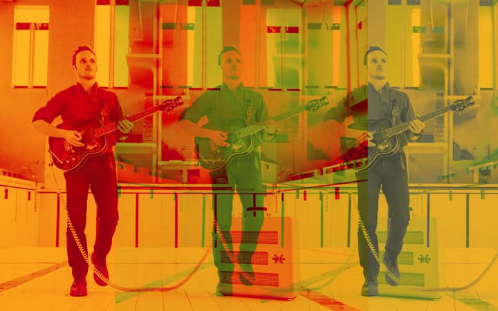 Oliver Richard playing guitar, triple-exposed in red, green and blue inside an empty swimming pool..